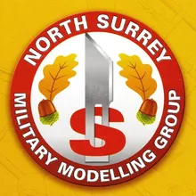 North Surrey Military Modelling Group club badge: a red roundel with oak leaves, acorns and a bayonet